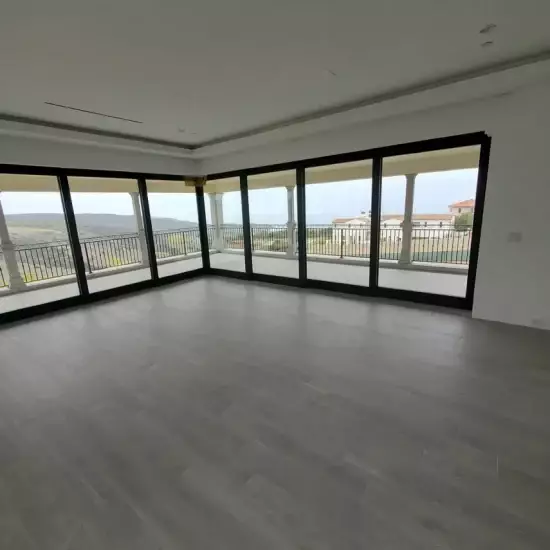 All Surfaces Flooring (1) Spacious room in Fort Mohave with floor-to-ceiling windows, gray tile flooring, and views of the balcony and landscape.