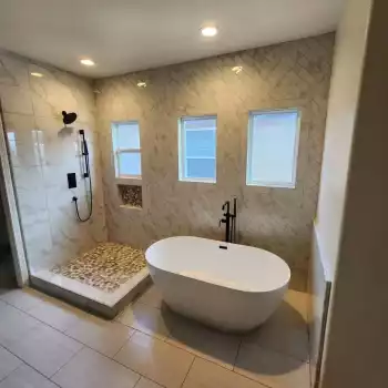 All Surfaces Flooring (8) Modern bathroom in Bullhead City with freestanding tub, walk-in shower, black fixtures, beige tile—remodel inspiration.