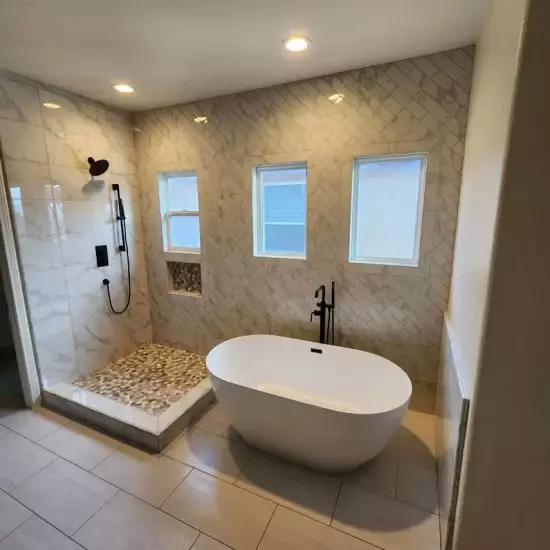 All Surfaces Flooring (8) Modern bathroom in Bullhead City with freestanding tub, walk-in shower, black fixtures, beige tile—remodel inspiration.